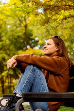 Şehir parkında dinlenen şehir kadını doğanın tadını çıkarıyor.