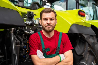 Traktörlerin arka planında tarım teknisyeninin portresi