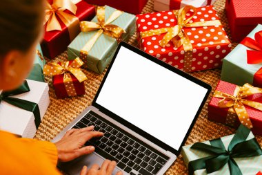 Female person using laptop with many gift boxes around