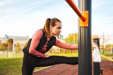 Kadın koşucu dışarıda idman yaptıktan sonra serinliyor.