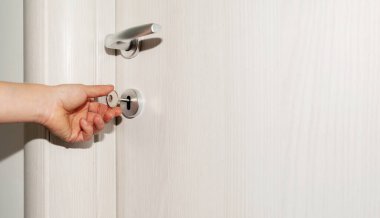 Kadın eli, anahtarı yakın plan ile kapıyı açar..