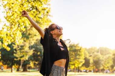 Şehir parkında eğlenen neşeli kadın.