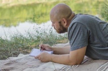 kel adam parkta bir çim üzerinde yalan