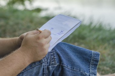 genç adam bir not defterinde yazıyor