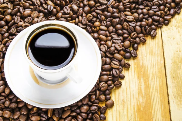 Tasse de café avec des grains sur une table — Photo