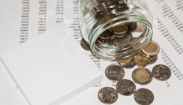 Närbild av euromynt i en glasburk, utspridda på bordet, begreppet sparande och investeringar Royaltyfria Stockfoton