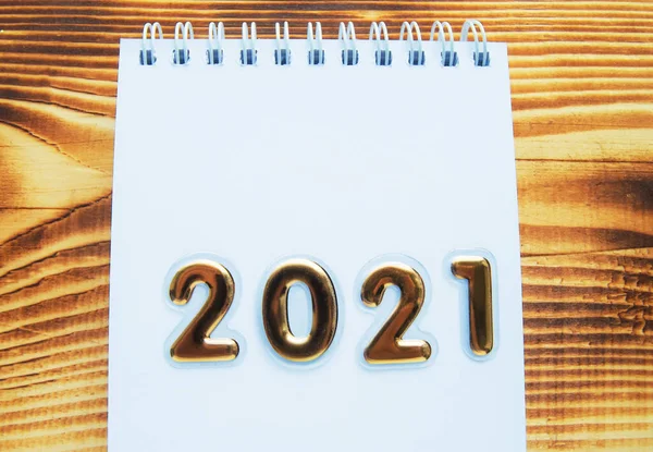 Yeni Yıl planınız kutlu olsun, üzerinde altın numaralar olan 2021 Notepad ve metin için boş alan, arkaplan tahtası