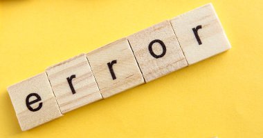 Tahta bloklarda ERROR yazıyor, ahşap bloklar sarı arka planda, üst manzara, düz ley