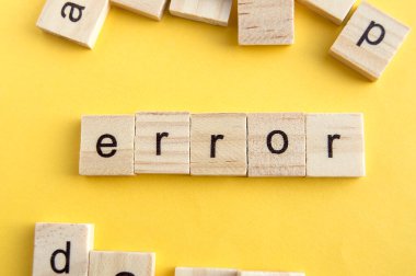 Tahta bloklarda ERROR yazıyor, ahşap bloklar sarı arka planda, üst manzara, düz ley