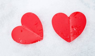 İki güzel romantik kırmızı kalp beyaz karlı bir arka planda birlikte. Aşk ve Sevgililer Günü kavramı