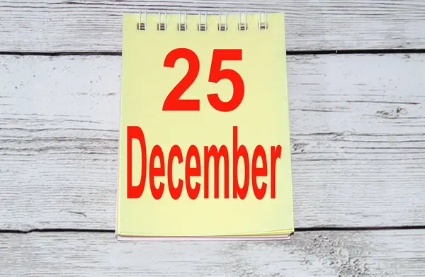 2021 geschreven in het rood op een geel notitieblok op een lichte houten achtergrond, het concept van Kerstmis en Nieuwjaar, minimalisme — Stockfoto