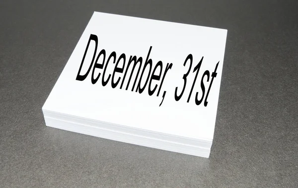 Na stosie papieru kwadratowego jest napisane 31 grudnia, ostatniego dnia roku, na czarnym tle — Zdjęcie stockowe
