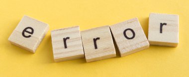 Tahta bloklarda ERROR yazıyor, ahşap bloklar sarı arka planda, üst manzara, düz ley