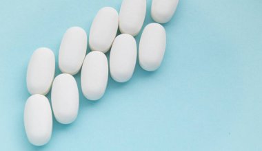 BLUE arkaplan üzerindeki beyaz tabletler iki sıra, kopyalama alanı, üst görünüm, farmakoloji konsepti