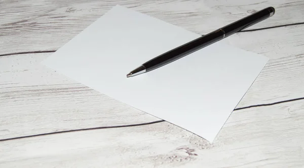 Boş bir defter ve açık tahta bir masa üzerinde siyah bir kalem, boşluğun bir kopyası, temiz bir sayfa açma kavramı.