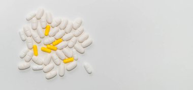 Beyaz arkaplanda bir grup beyaz ve sarı tablet, yakın plan, kopyalama alanı, metin için boşluk, pankart