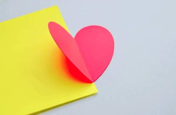 Sarı-gri kağıt zemin üzerinde güzel katlanmış kırmızı kalp, yakın plan, Sevgililer Günü