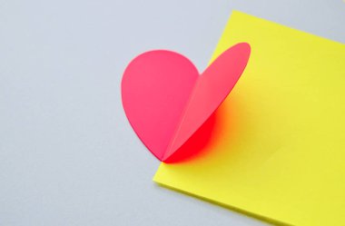 Sarı-gri kağıt zemin üzerinde güzel katlanmış kırmızı kalp, yakın plan, Sevgililer Günü