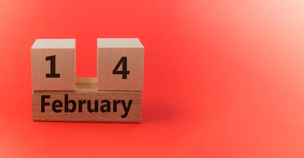 Calendario de bloques de madera con la fecha 14 de febrero sobre un fondo festivo rojo con una copia del espacio —  Fotos de Stock
