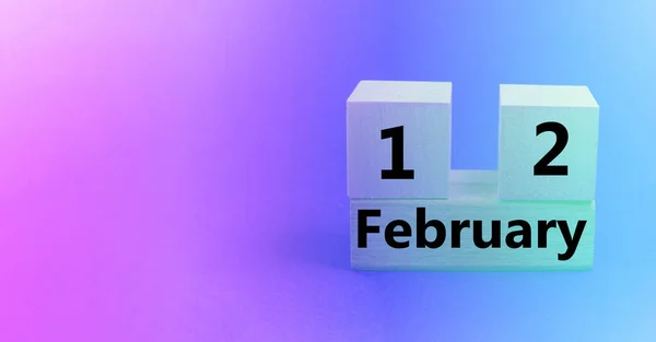 Calendar for February 12 on a wooden cube, gradient pink and purple background, empty space for text, banner — Stock Photo, Image