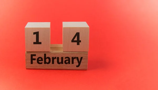 Calendario de bloques de madera con la fecha 14 de febrero sobre un fondo festivo rojo con una copia del espacio — Foto de Stock