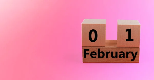 Wooden block calendar with date February 01 on pink gradient holiday background with copy space and space for your text — Stock Photo, Image