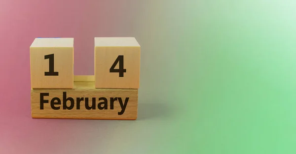 Gradient green pink background with wooden block calendar with date February 14 with copy space and space for your text — Stock Photo, Image