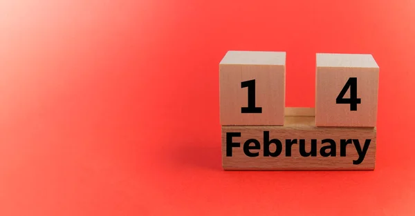 Calendario de bloques de madera con la fecha 14 de febrero sobre un fondo festivo rojo con una copia del espacio —  Fotos de Stock