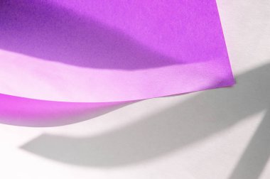 Beyaz arka planda mor kıvrımlı bir kağıt yap. Geometrik desenli gölge örtülü yaratıcı kağıt modeli