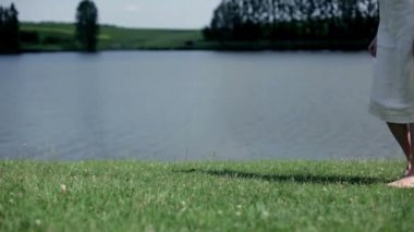 Göl kenarında yürüyen genç kadın