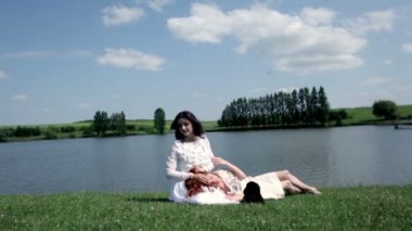 Göl kenarında oturan genç kadın