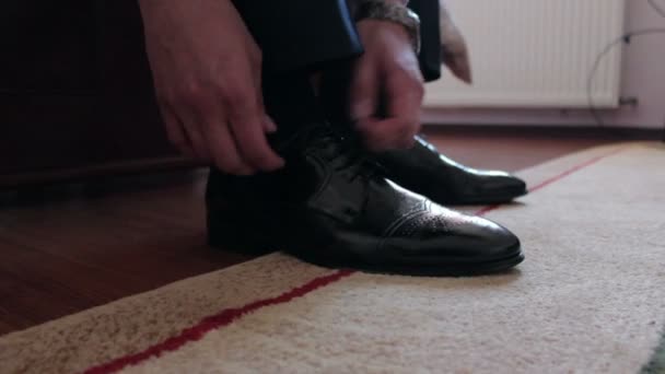Человек завязывающий шнурки — стоковое видео