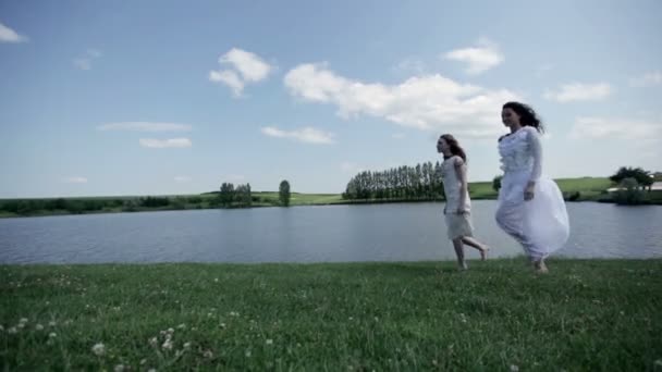 Jonge vrouwen wandelen in de buurt van lake — Stockvideo