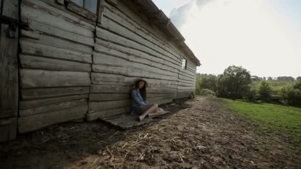 Jeune femme près de maison en bois — Video