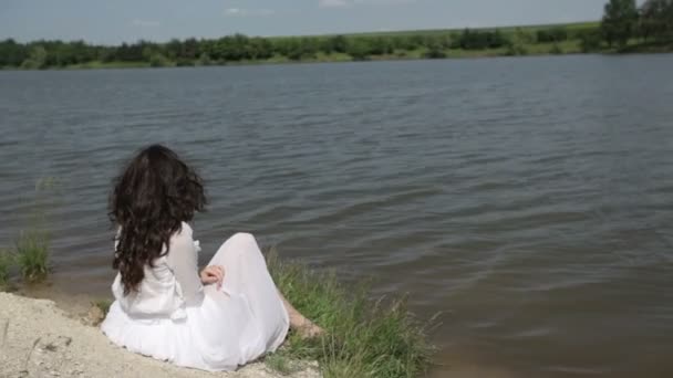 Молода жінка біля озера — стокове відео