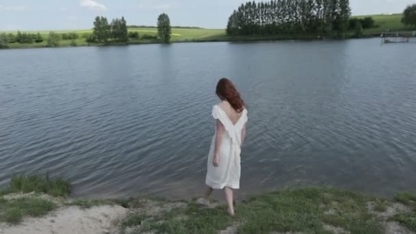 Молодая женщина, ходящая в воде — стоковое видео