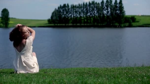 Молодая женщина у озера — стоковое видео