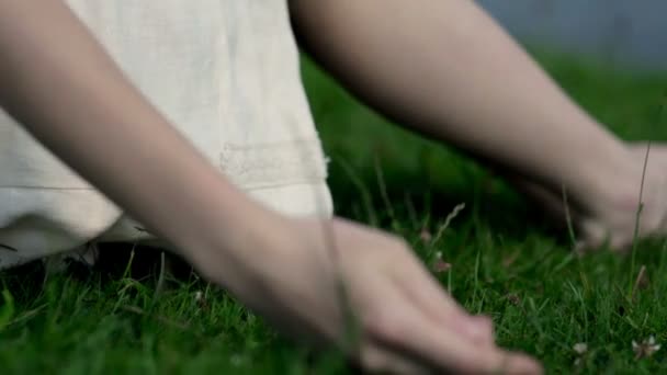 mains féminines touchant l'herbe 