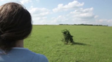 Genç kadın sahada koşuyor.