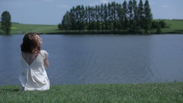 Молодая женщина у озера — стоковое видео