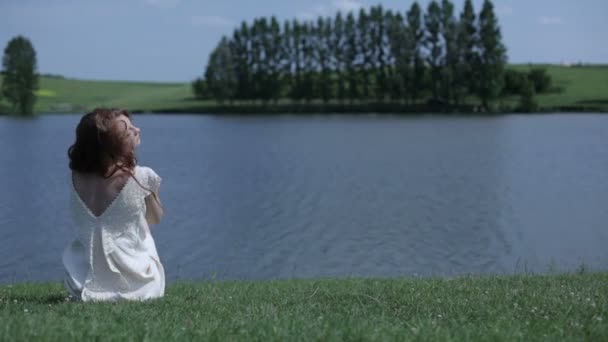 Jonge vrouw in de buurt van lake — Stockvideo