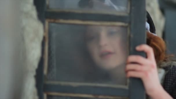 身着民族服装的快乐女孩冲刷着一幢老房子的破窗户. — 图库视频影像