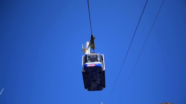 La cabine se déplace le long d'un téléphérique sur fond de ciel bleu vif. Flou — Video