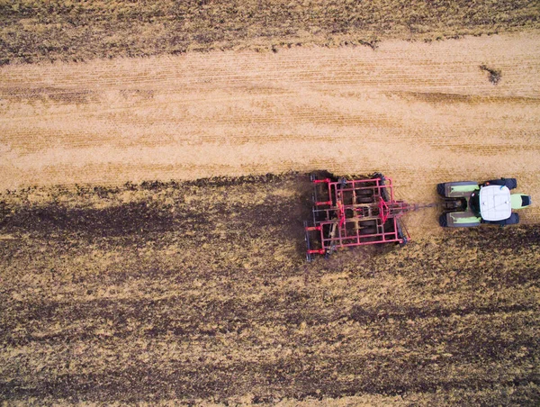 Harvesting in the field. Aerial view. Land cultivation with a tractor — Stock Photo, Image