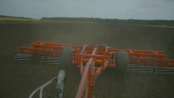 Сбор урожая в поле. Земледелие с трактором — стоковое видео
