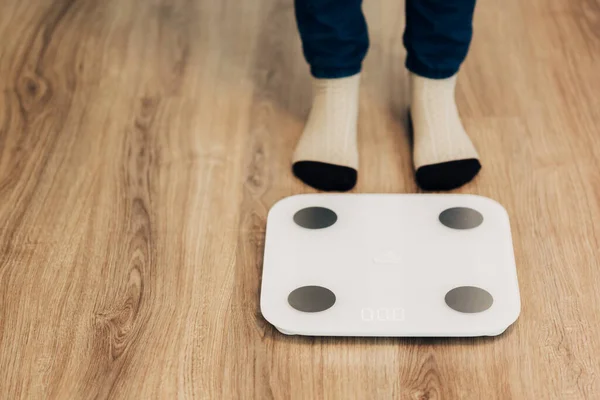 Girl Measures Weight on Smart Scales. Modern Electronic Device.