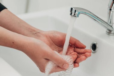 Kız enfeksiyonu önlemek için ellerini yıkar. Virüs COVID-19.