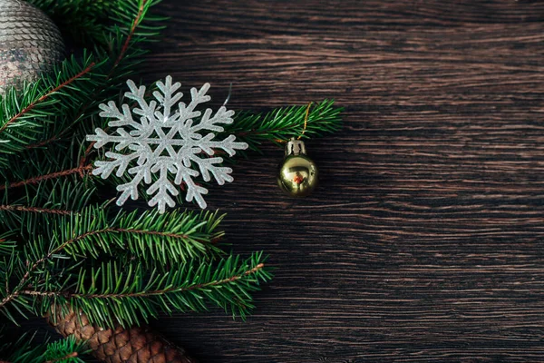 Ramas de árboles de Navidad y copos de nieve sobre un fondo marrón con CopySpace —  Fotos de Stock