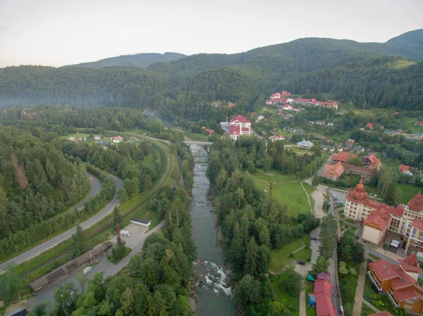 Dorf in der Nähe tiefgrüner Berge. Luftaufnahme. — Stockfoto