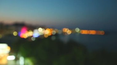 Güzel sahil şeridi boyunca otellerin ve yazlık kafelerin parlak ışıkları. bokeh. Harika bir yaz tatili konsepti